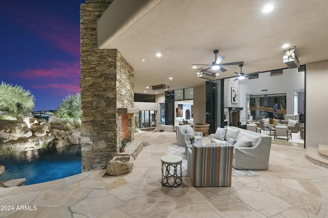 patio terrace at dusk featuring an outdoor living space and ceiling fan