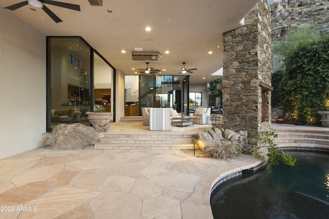 view of patio / terrace featuring an outdoor living space with a fireplace and ceiling fan