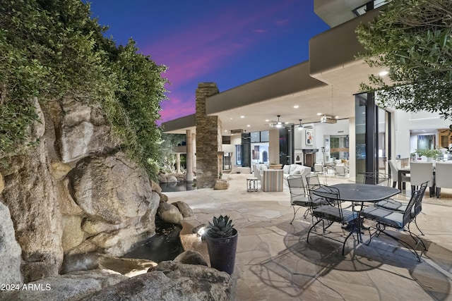 patio terrace at dusk featuring ceiling fan