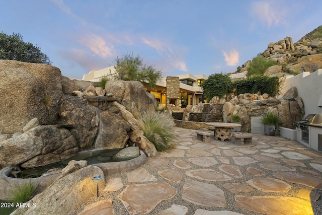 patio terrace at dusk with exterior kitchen