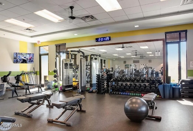 exercise room featuring a paneled ceiling, visible vents, and a ceiling fan