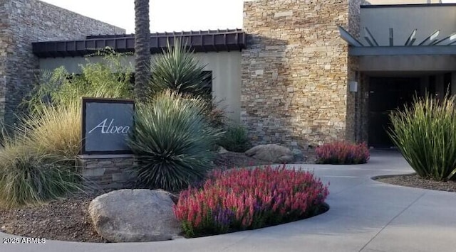 exterior space featuring stone siding and stucco siding