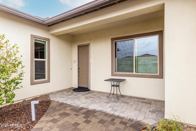 property entrance featuring a patio and stucco siding