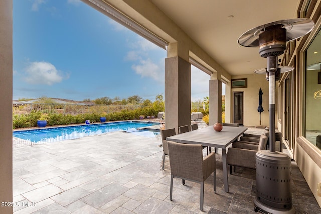 view of patio with outdoor dining area and a fenced in pool