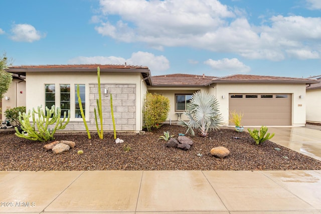 prairie-style home featuring driveway, a tiled roof, an attached garage, and stucco siding