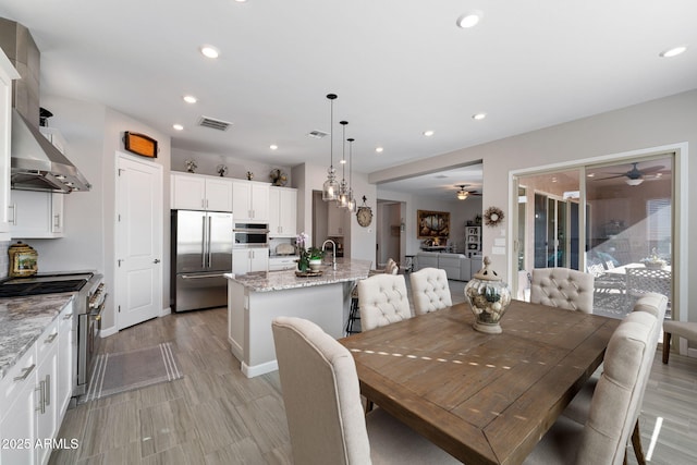 dining area featuring light wood-style flooring, a ceiling fan, visible vents, and recessed lighting