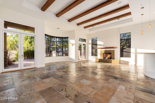 unfurnished living room featuring beamed ceiling and french doors