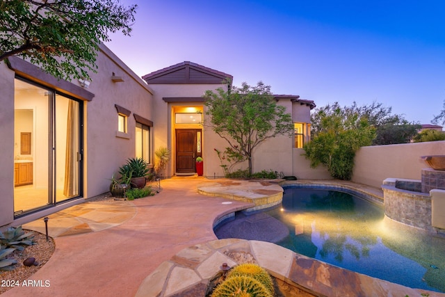 pool at dusk featuring a patio area