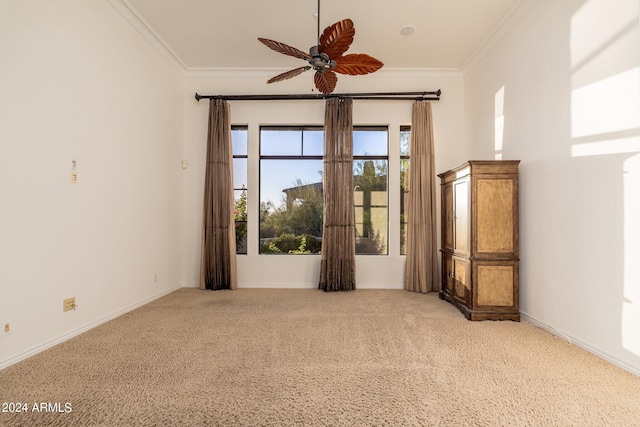 carpeted empty room with ceiling fan and ornamental molding