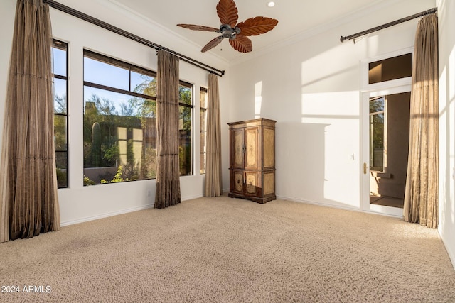 unfurnished room with ornamental molding, ceiling fan, and carpet floors