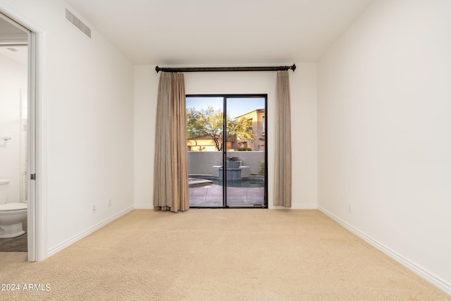 unfurnished room featuring light carpet