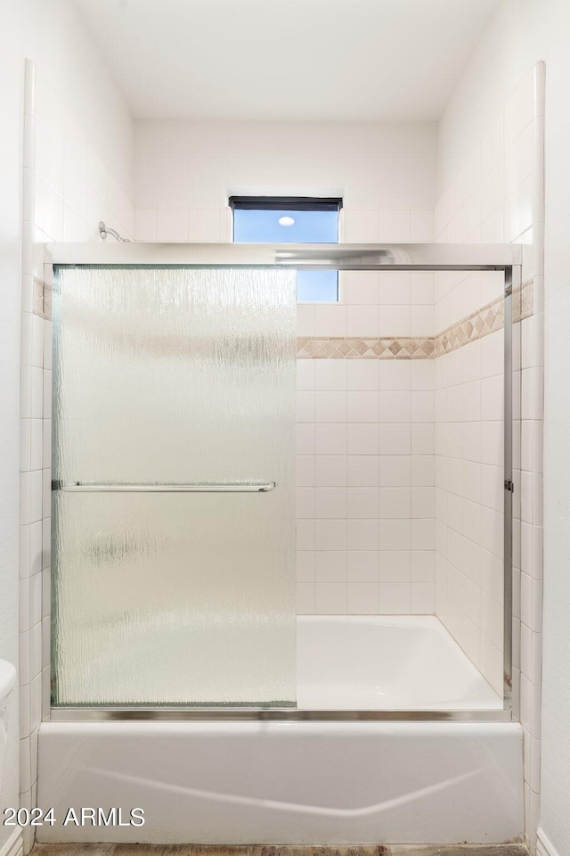 bathroom with shower / bath combination with glass door