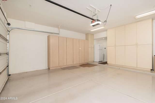 garage featuring a garage door opener and white fridge