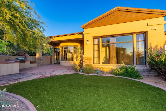 back of house featuring a lawn and a patio