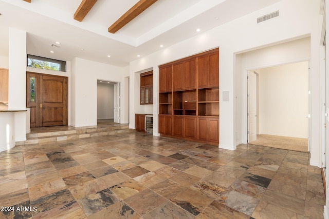 unfurnished living room featuring beamed ceiling