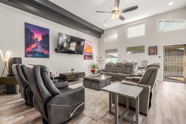 interior space featuring light hardwood / wood-style floors, ceiling fan, and a high ceiling