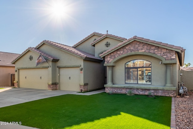 mediterranean / spanish house with a garage and a front yard