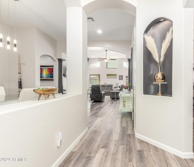 hallway featuring decorative columns and hardwood / wood-style floors