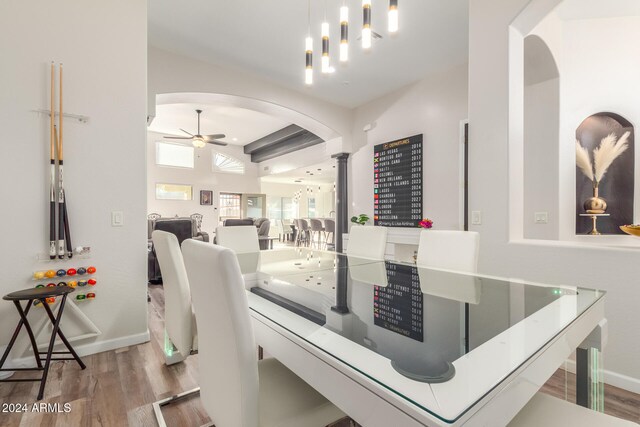 dining space featuring ceiling fan, wood-type flooring, and decorative columns