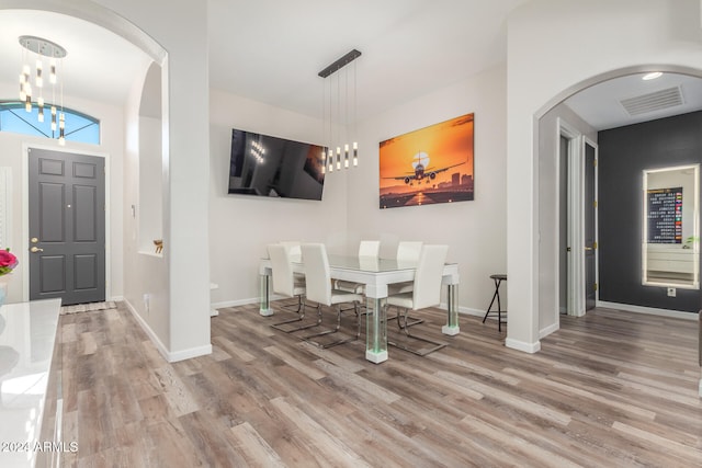 dining space with hardwood / wood-style flooring and a chandelier