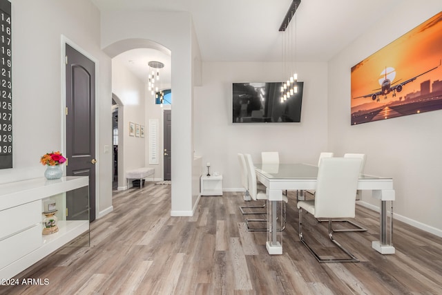 dining space with hardwood / wood-style flooring and a notable chandelier