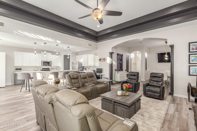 living room featuring ceiling fan, ornate columns, and light hardwood / wood-style floors