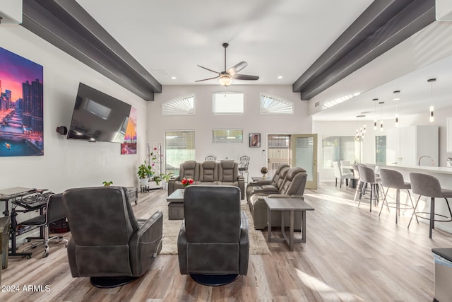 living room with ceiling fan, hardwood / wood-style flooring, and a high ceiling