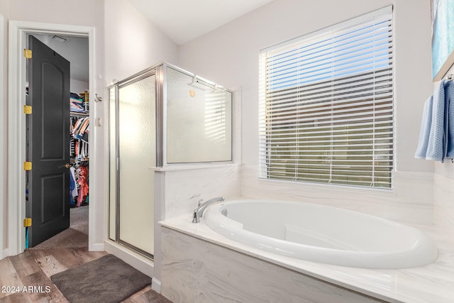 bathroom with wood-type flooring, plenty of natural light, and shower with separate bathtub