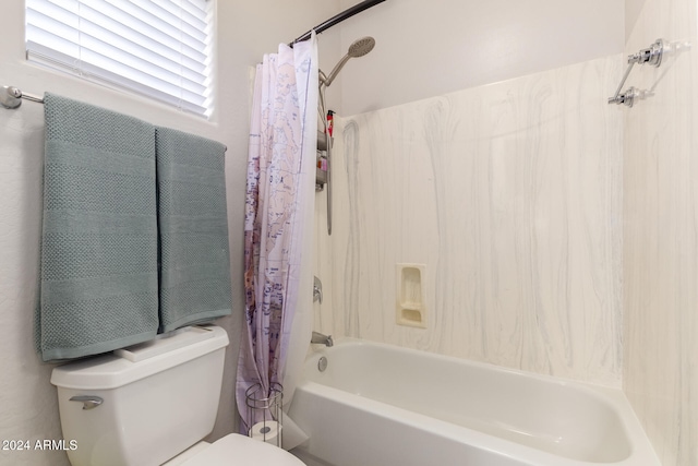 bathroom featuring shower / tub combo with curtain and toilet