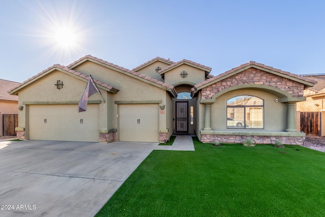 mediterranean / spanish home featuring a garage and a front yard