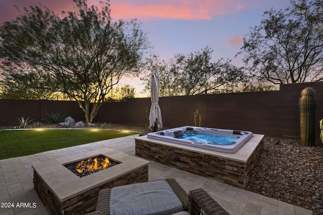 patio terrace at dusk with a fire pit and an outdoor hot tub