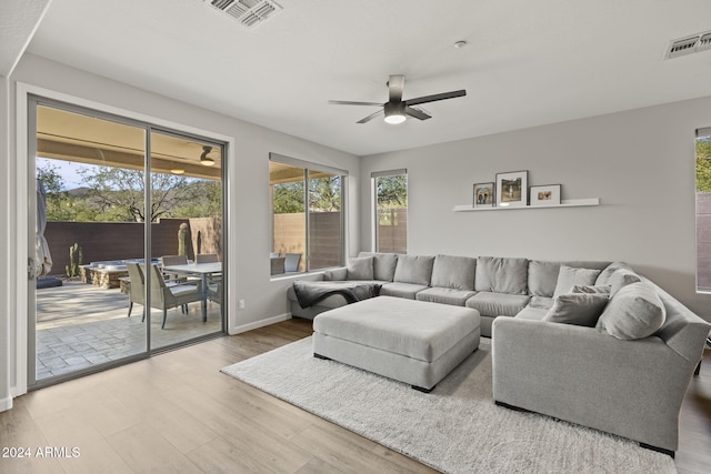 living room with wood-type flooring and ceiling fan