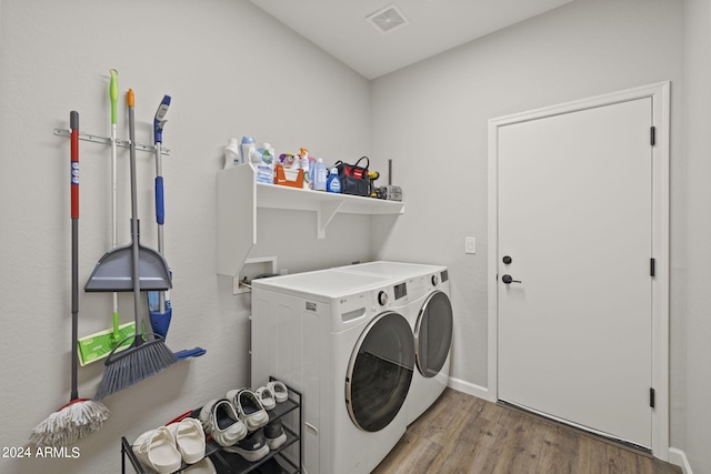 laundry area featuring washer and dryer and light hardwood / wood-style flooring