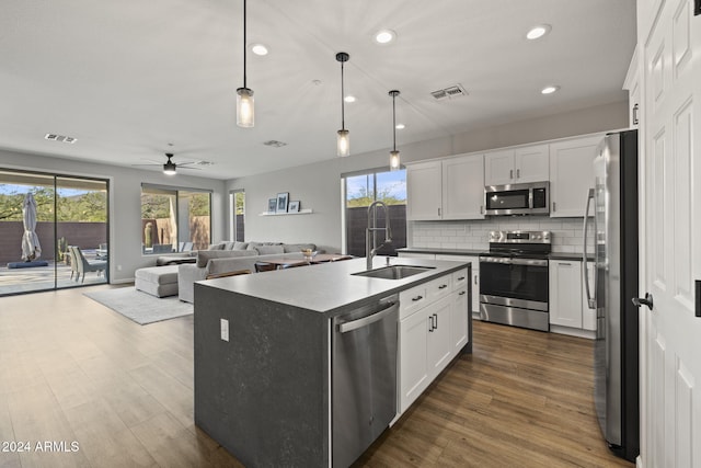 kitchen with a kitchen island with sink, dark wood-type flooring, sink, white cabinetry, and appliances with stainless steel finishes