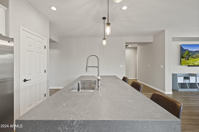 kitchen with stainless steel refrigerator, pendant lighting, sink, dark hardwood / wood-style floors, and white cabinetry