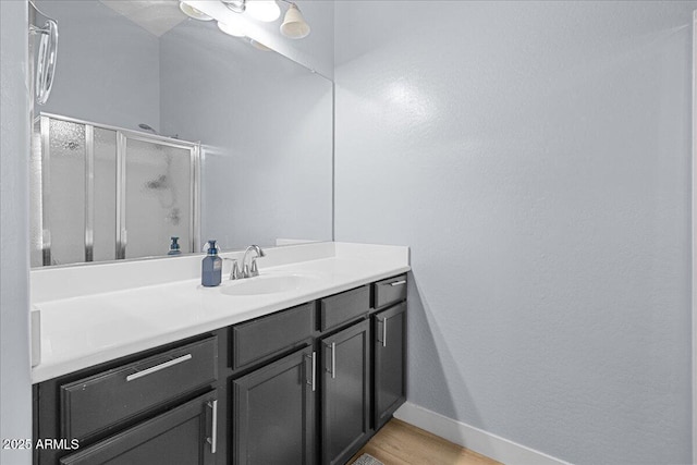 5026 S 235th Dr, Buckeye, AZ 85326 - bathroom with a shower stall, vanity, wood finished floors, and a textured wall