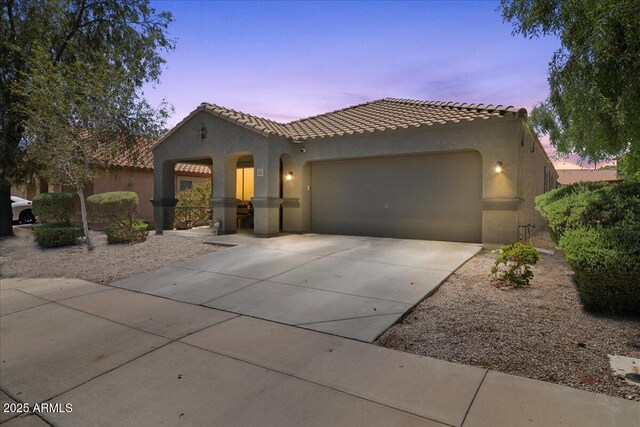 5026 S 235th Dr, Buckeye, AZ 85326 - mediterranean / spanish-style house with stucco siding, an attached garage, driveway, and a tiled roof