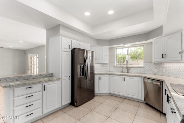 kitchen featuring stainless steel appliances, a peninsula, backsplash, and white cabinets