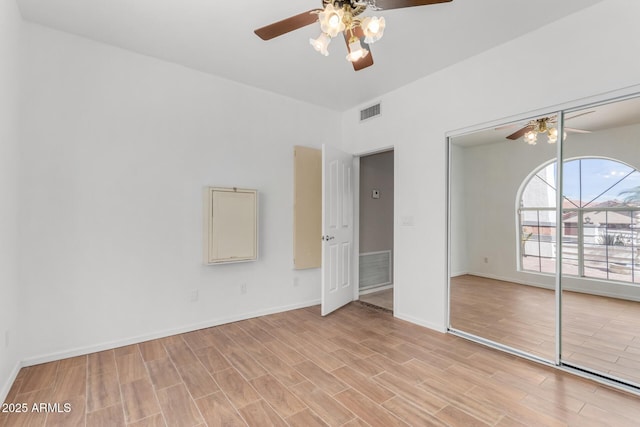 unfurnished bedroom with light wood finished floors, a closet, visible vents, a ceiling fan, and baseboards