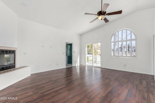 unfurnished living room featuring high vaulted ceiling, dark wood-type flooring, a ceiling fan, and baseboards