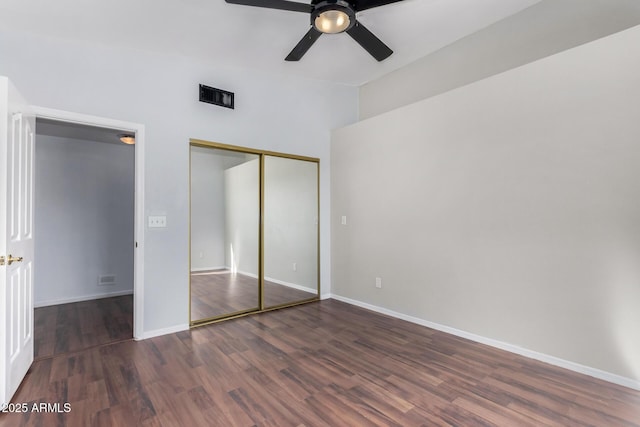 unfurnished bedroom featuring baseboards, visible vents, a ceiling fan, dark wood-type flooring, and a closet