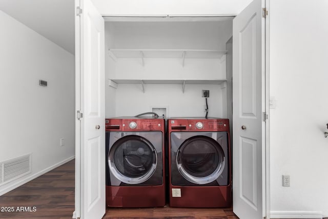 laundry area featuring dark wood-type flooring, washing machine and dryer, laundry area, and visible vents