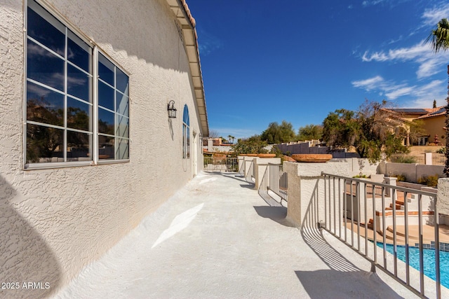 exterior space with a fenced in pool, a patio area, fence, and stucco siding