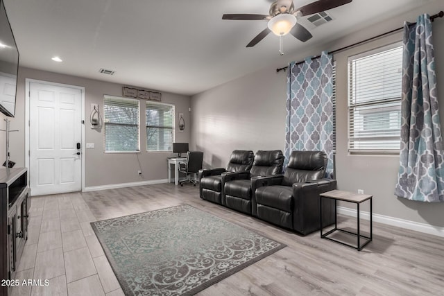 living room featuring light wood-style flooring, baseboards, and visible vents