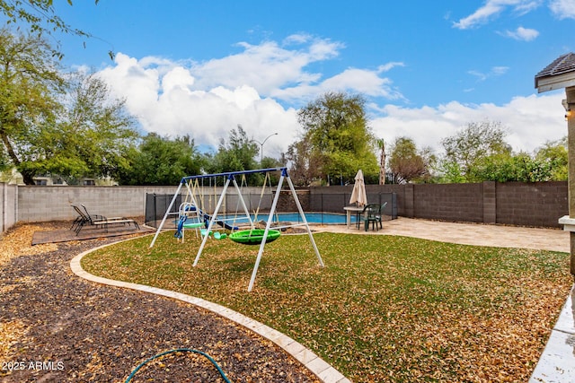 view of play area featuring a fenced backyard, a lawn, and a patio