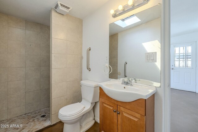 7737 W Medlock Dr, Glendale, AZ 85303 - bathroom with visible vents, toilet, a tile shower, a skylight, and vanity
