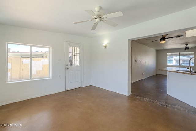 7737 W Medlock Dr, Glendale, AZ 85303 - interior space with baseboards, finished concrete flooring, ceiling fan, and a sink