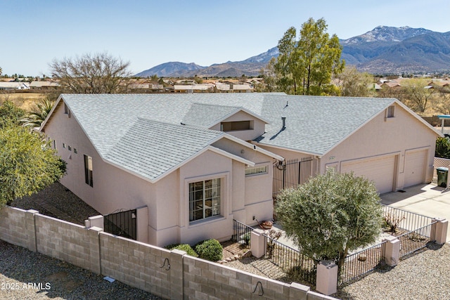 view of front of house featuring roof with shingles, fence private yard, and stucco siding