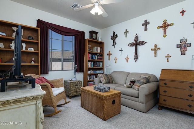 sitting room featuring carpet floors, visible vents, and a ceiling fan