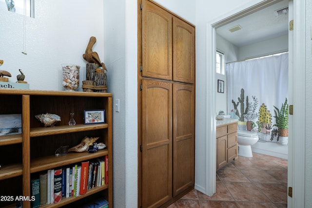 bathroom with visible vents, vanity, toilet, and tile patterned floors